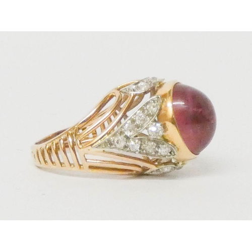 697 - A statement dress ring, set with a large oval cabochon on diamond shoulders in 18ct yellow gold. Rin... 