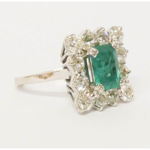 698 - An impressive emerald and diamond ring, of square design, the central emerald measures 10mm x 8mm ap... 