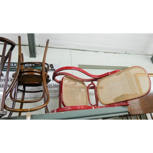 23 - A pair of round seat Bentwood chairs and a red painted rocking elbow chair with cane panel seat and ... 