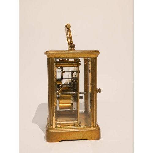 541 - A carriage clock in brass and glass case with white enamel dial signed J w Benson