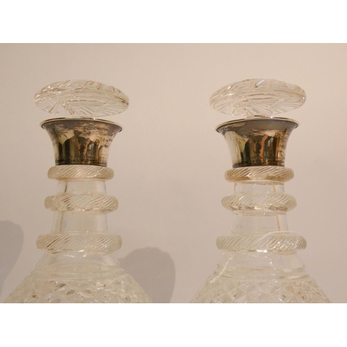 533 - A pair of cut glass decanters with silver rims, each 10