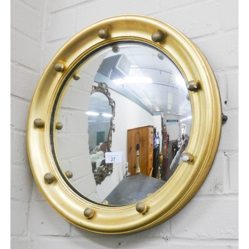 27 - A circular convex wall mirror in gilt frame