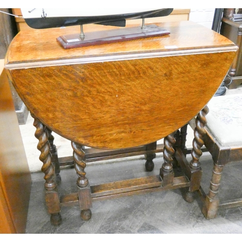 43 - An oval oak gate leg table on barley twist legs, 2'6 wide