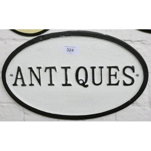 286 - A cast iron wall hanging oval shaped 'Antiques' sign