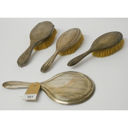 519 - Three silver backed hairbrushes and a silver backed mirror