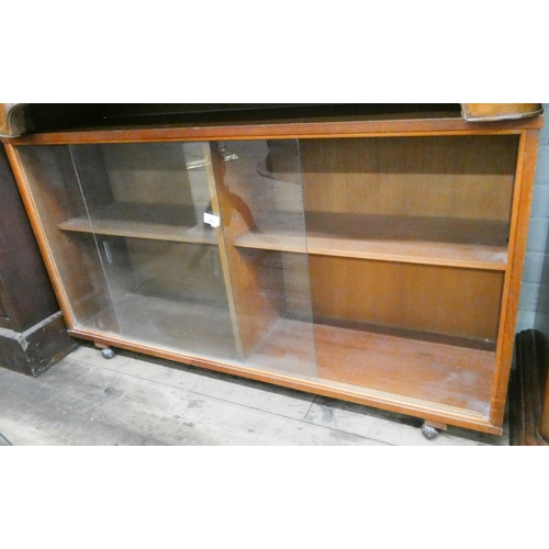 24 - A low teak bookcase with sliding glass doors, 3'9 wide