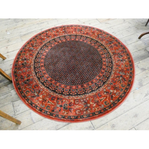 96 - A circular red and patterned wool pile rug