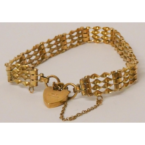 614 - A 9ct yellow gold gate bracelet with heart shaped padlock fastening. 12.1 grams