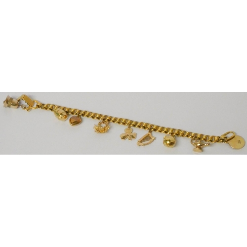 619 - A charm bracelet - unmarked yellow metal bracelet - tests as 9ct gold, set with numerous hallmarked ... 