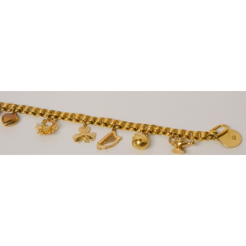 619 - A charm bracelet - unmarked yellow metal bracelet - tests as 9ct gold, set with numerous hallmarked ... 