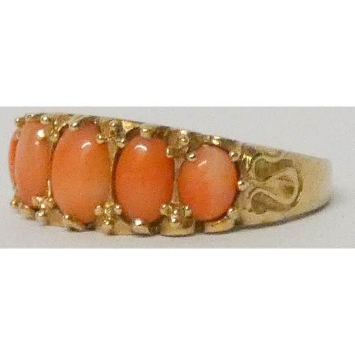 596 - A five stone coral ring in carved 9ct yellow gold setting, ring size N