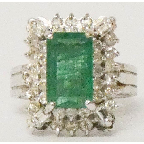 648 - 18ct white gold emerald and diamond rectangular cluster ring, in a raised three tier setting, ring s... 