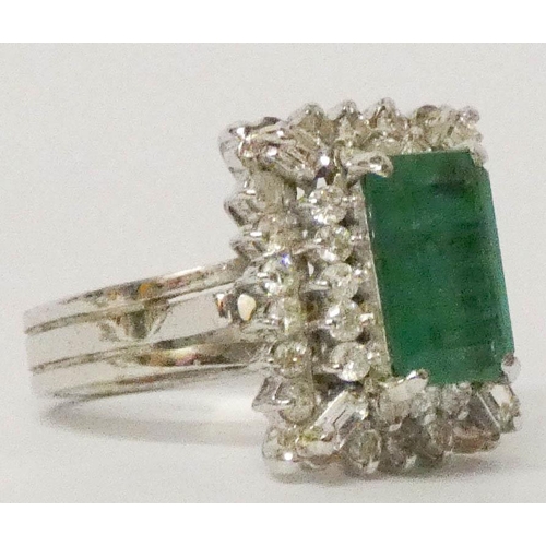 648 - 18ct white gold emerald and diamond rectangular cluster ring, in a raised three tier setting, ring s... 