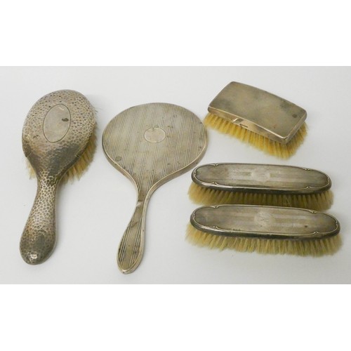 573 - Four various silver backed brushes and a silver backed hand mirror