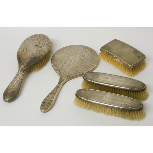 573 - Four various silver backed brushes and a silver backed hand mirror