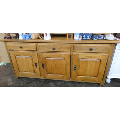 10 - A heavy light oak three door and drawer sideboard, 6'6 wide, matching the previous table