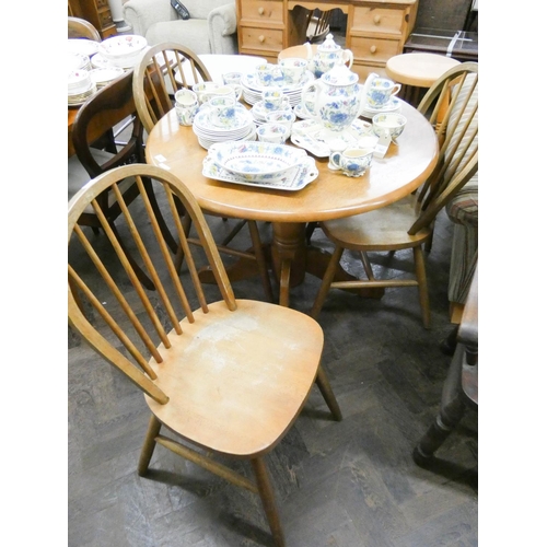 106 - circular oak dining table on single pillar base together with three stick back Windsor dining chairs