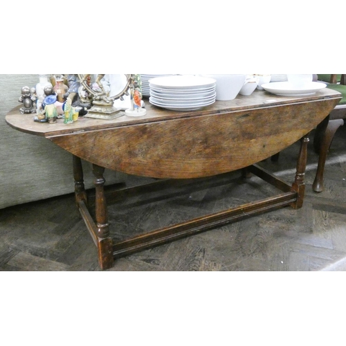 116 - A low oval drop leaf coffee table on turned legs, 4'6 wide