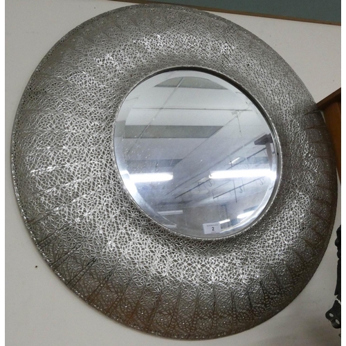 2 - A circular bevelled wall mirror in a pierced silver metal frame