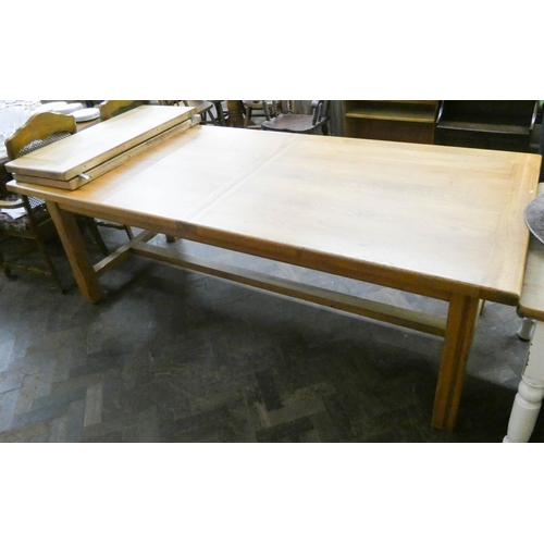 9 - A large modern heavy light oak dining table with two centre leaves, standing on heavy refectory styl... 