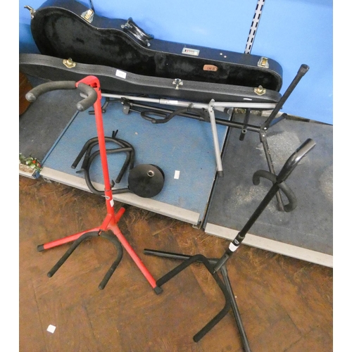 454 - Four guitar stands and one good quality Gibson guitar case and other guitar stand parts