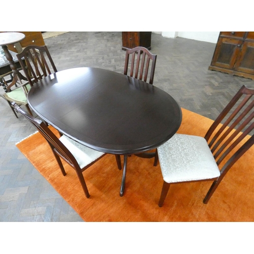 59 - An oval mahogany extending dining table and four matching chairs with upholstered seats