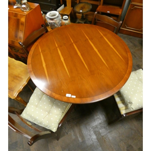 238 - A circular reproduction yew wood single pillar dining table together with four Regency style chairs