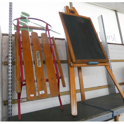 398 - A child's blackboard on easel and an Alpine metal and wood sledge