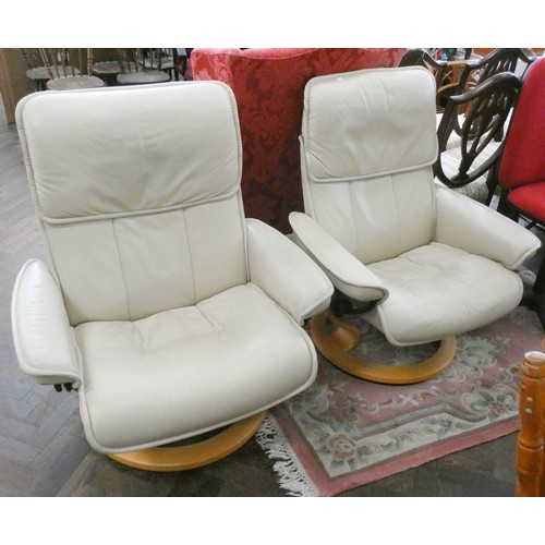 249 - Pair of Ekornes Stressless revolving reclining chairs in cream leather