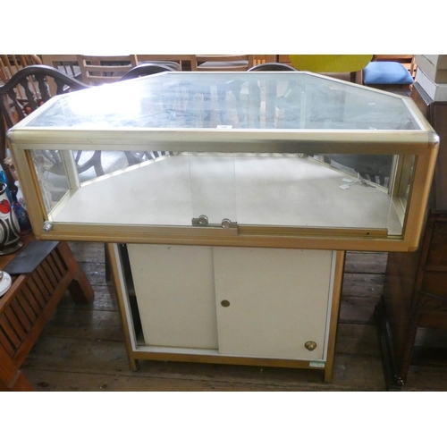 109 - A glass display cabinet with sliding doors standing on a cupboard base