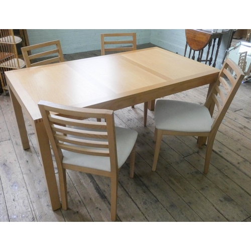 63 - A modern light oak dining table and four matching ladder back style chairs with upholstered seats