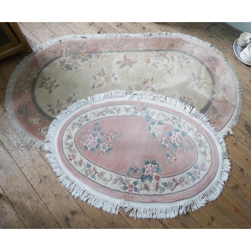 89 - Two pink and patterned oval Chinese rugs