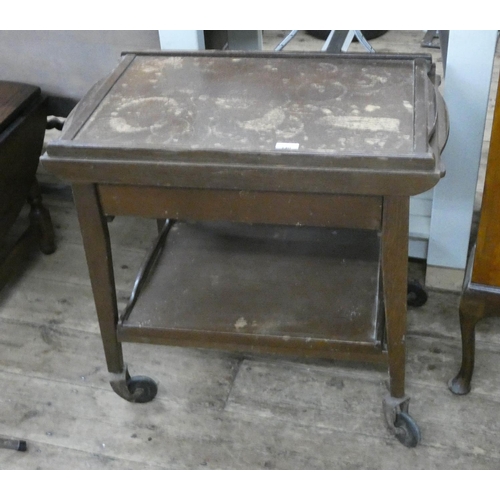 140 - Two tier oak tea trolley with lift off trays and fitted drawer