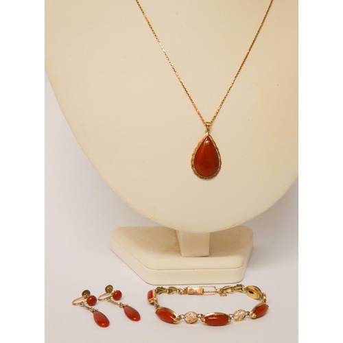 659 - A Chinese red coral and gold suite of jewellery - an oval panel bracelet, pendant necklace on gold c... 