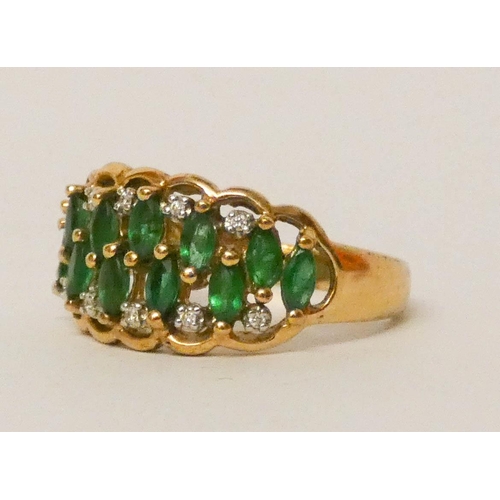 582 - An emerald and diamond ring, set two rows of marquise shaped emeralds within diamond borders on a wi... 