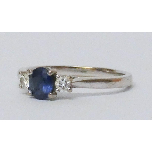 583 - A sapphire and diamond three stone ring, on 18ct white gold hallmarked band, ring size O