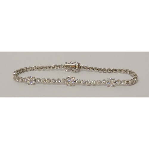 627 - A diamond line bracelet, of brilliant cut diamonds, further set with three diamond clusters, 18ct wh... 