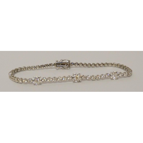 627 - A diamond line bracelet, of brilliant cut diamonds, further set with three diamond clusters, 18ct wh... 