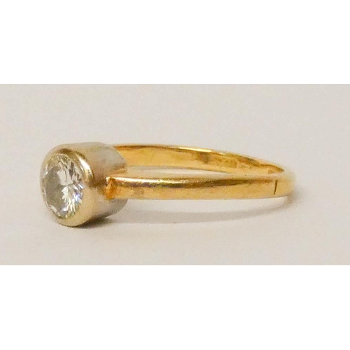 691 - A diamond solitaire ring, in an 18ct yellow gold rub over setting, hallmarked, ring size K