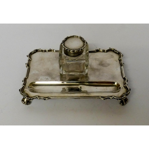 569 - A silver inkstand, with a square cut glass bottle of rectangular form, London 1931, 15cms across