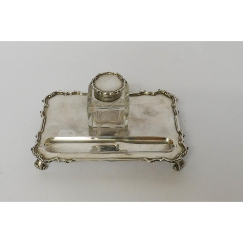 569 - A silver inkstand, with a square cut glass bottle of rectangular form, London 1931, 15cms across