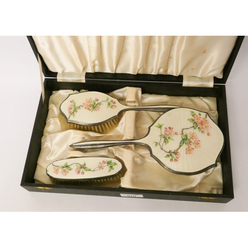 570 - A hallmarked silver and enamel backed three piece dressing table set, decorated with cherry blossom ... 