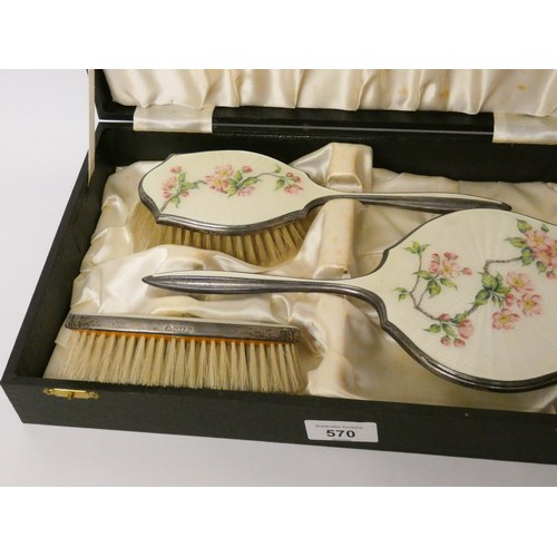 570 - A hallmarked silver and enamel backed three piece dressing table set, decorated with cherry blossom ... 