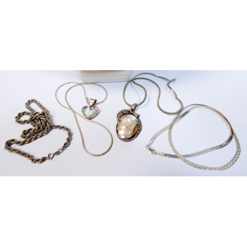 661 - A collection of silver chains and pendants and a large Buddhist silver Om pendant on leather cord.