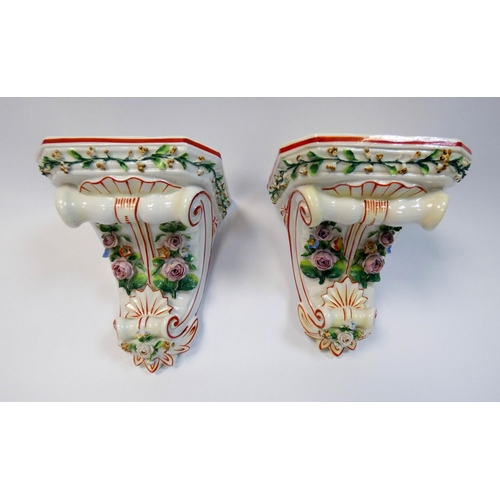 501 - A pair of continental porcelain floral encrusted wall brackets, 16 cms tall.