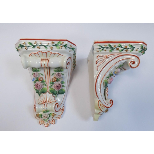 501 - A pair of continental porcelain floral encrusted wall brackets, 16 cms tall.