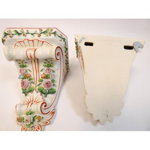 501 - A pair of continental porcelain floral encrusted wall brackets, 16 cms tall.