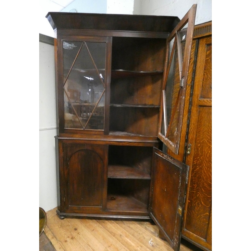 202 - A large Georgian mahogany glazed two door corner cabinet standing on a cupboard base, 46