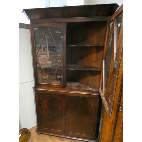 202 - A large Georgian mahogany glazed two door corner cabinet standing on a cupboard base, 46