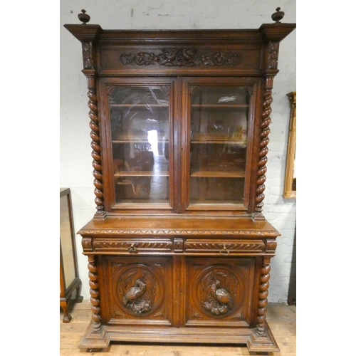 211 - A French Henry II carved oak glazed bookcase with barley twist columns standing on a cupboard base w... 